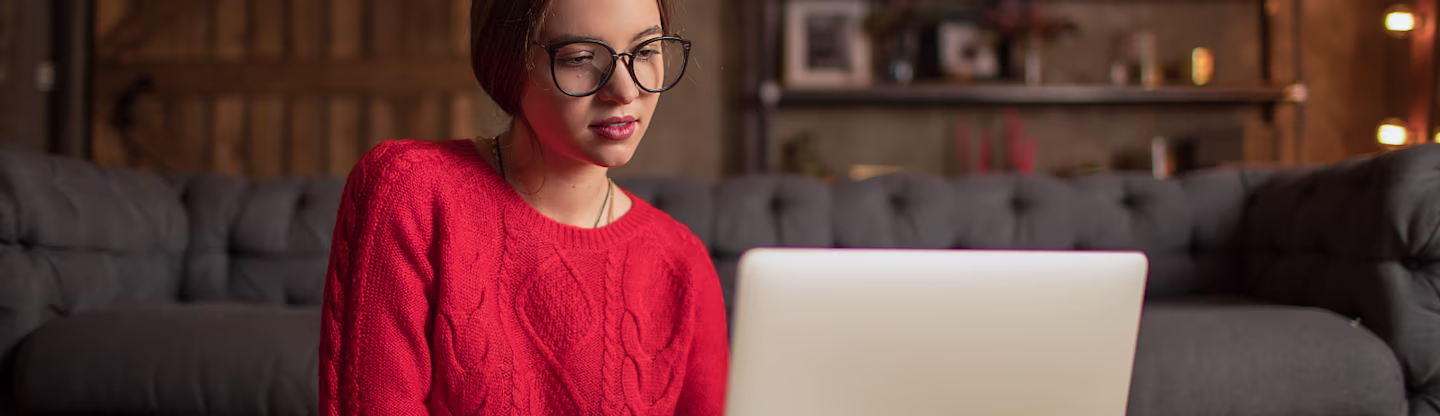 Front profile of a university building with trees and pavements leading up to the entrance