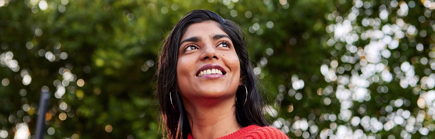 A female IELTS test taker within the campus in an orange top