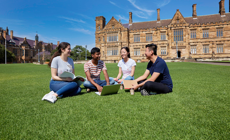 Four students sit on a university lawn and discuss about IELTS