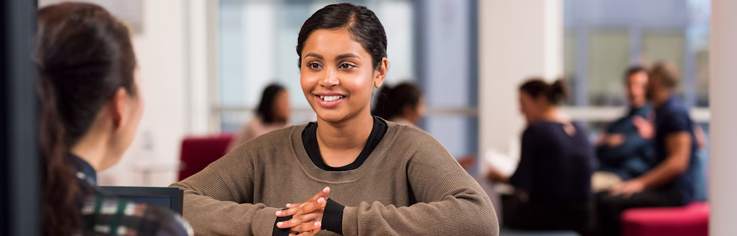 A female test taker talks to an IELTS test staff