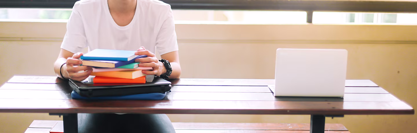 Male IELTS test taker wearing a white t-shirt preparing for IELTS test with preparation material