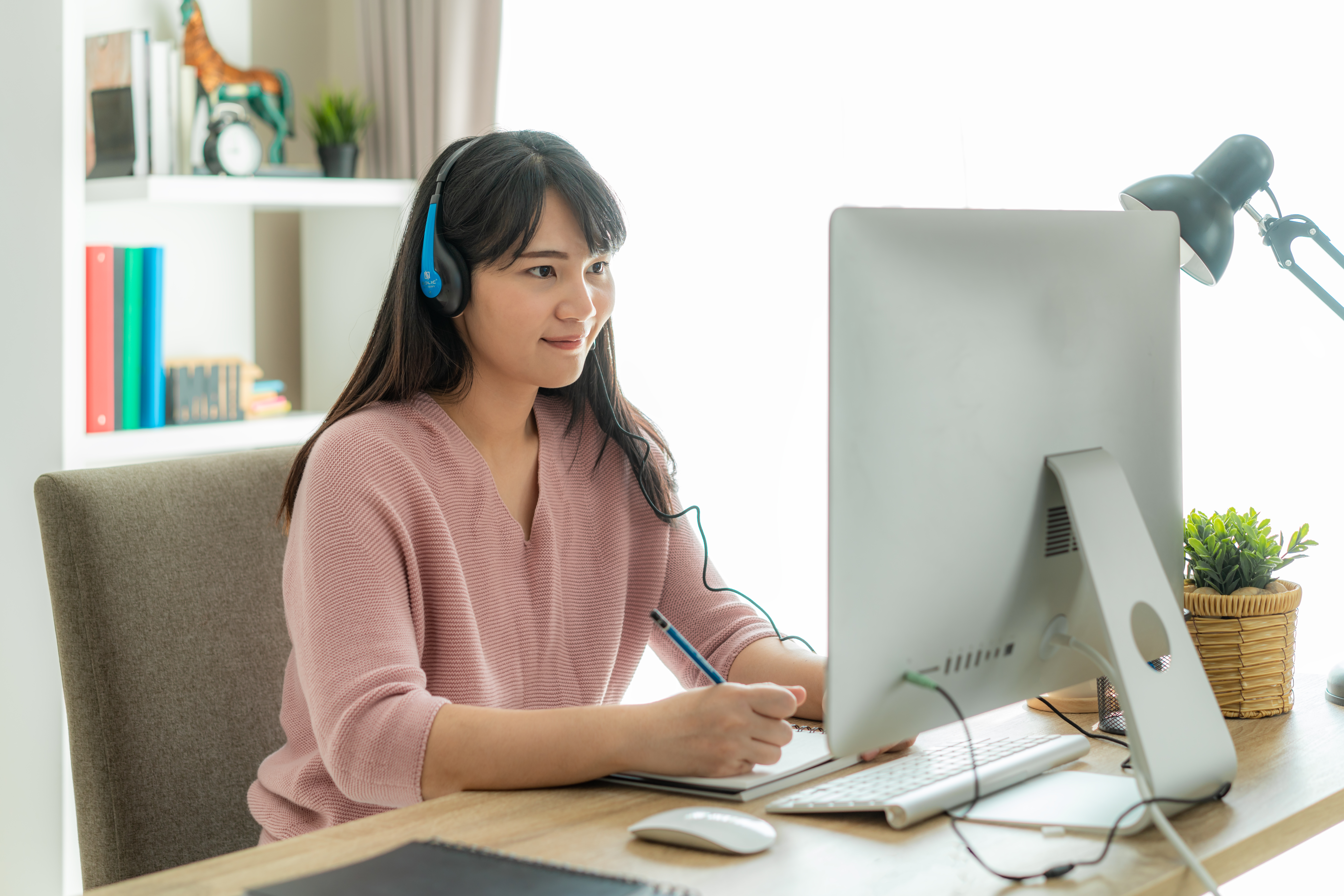 Female test taker practices for the IELTS Listening test on a computer