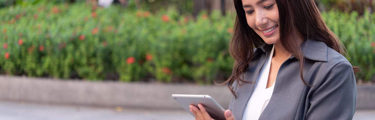 Female IELTS test taker in a grey suit looking at her tablet