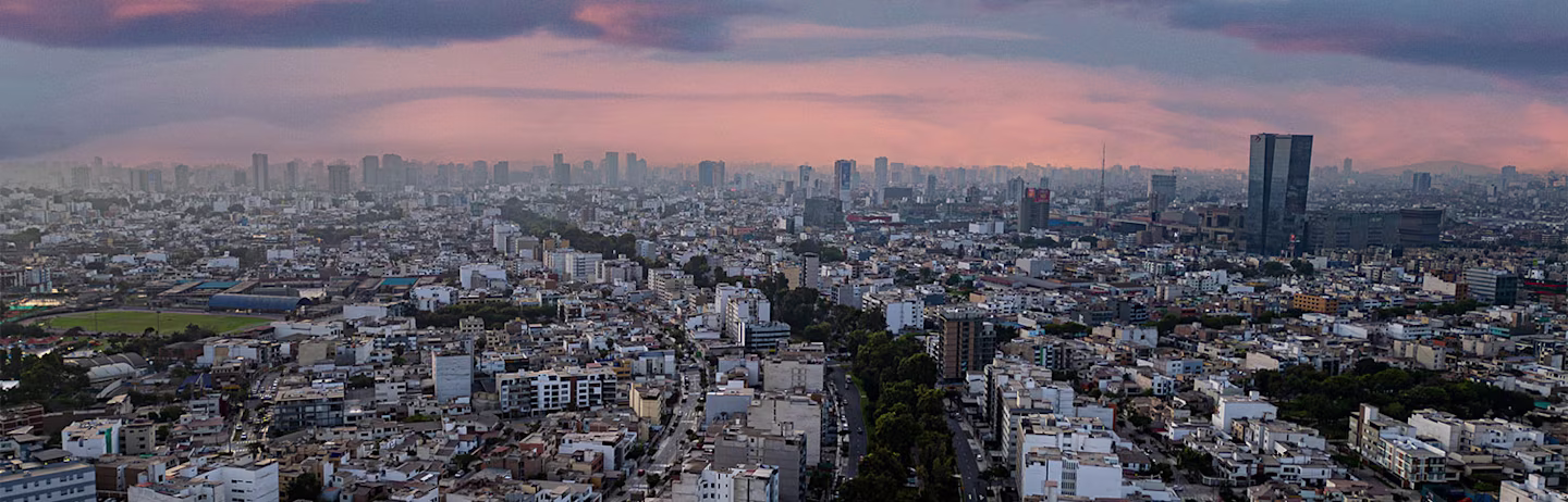 Aerial photography capturing the vibrant and bustling San Borja district of Lima, Peru, on a warm orange summer afternoon