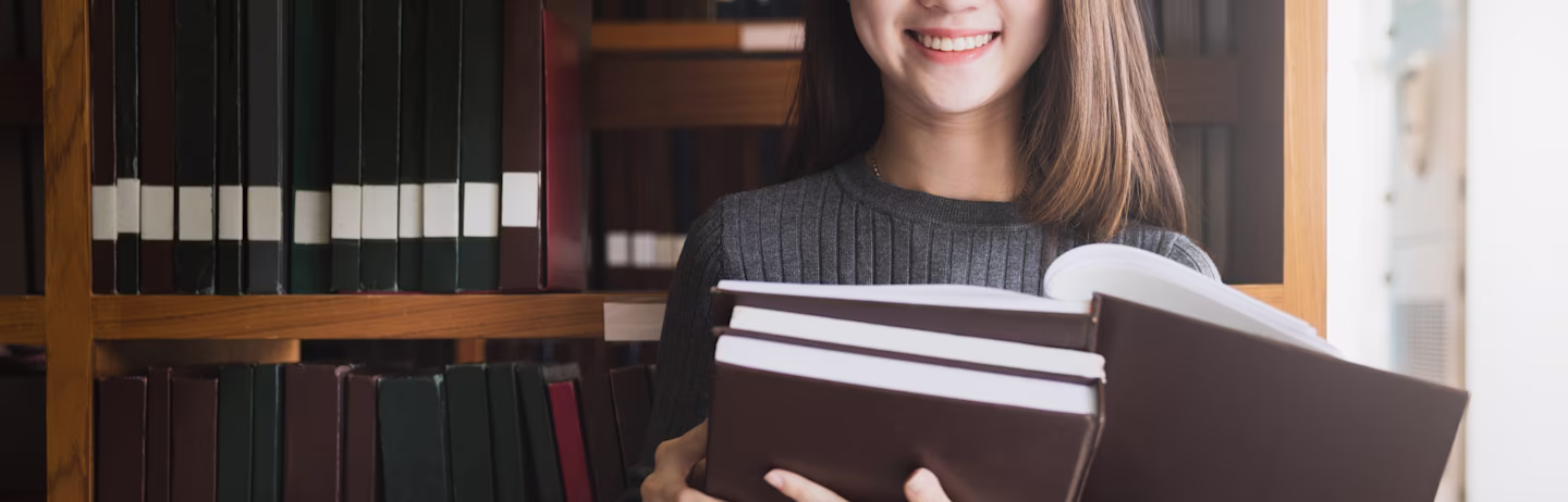 Female IELTS test taker in grey full-sleeve t-shirt preparing for IELTS in a library