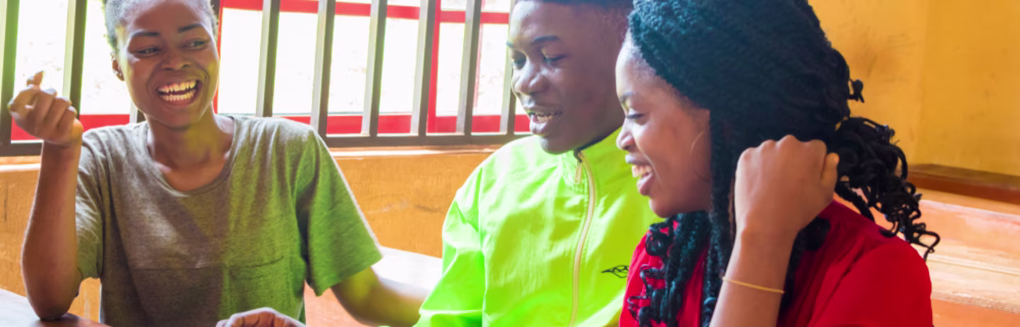A group of students smile happily while they prepare for the IELTS test