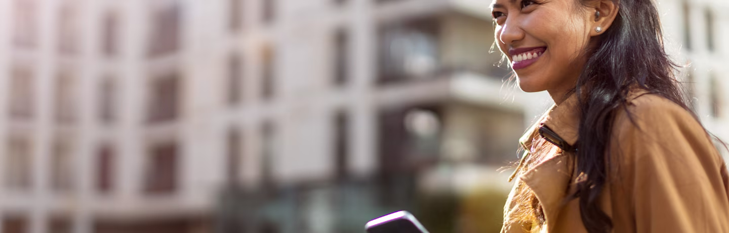 Female IELTS test taker holding a coffee and a phone