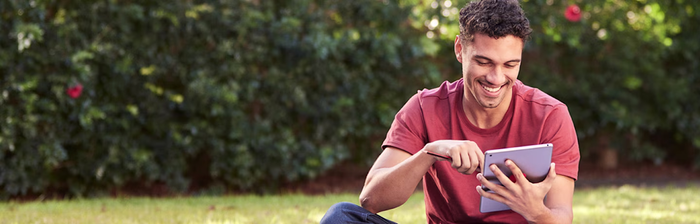 Smiling person looking at a tablet