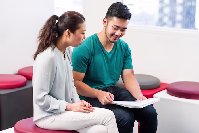 Test takers runs through the check-in process with a test centre staff member