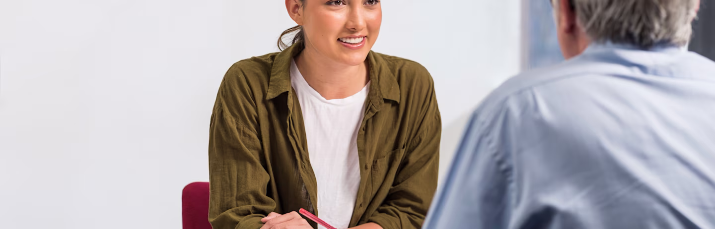 Female test taker speaks to a male IELTS examiner during the IELTS Academic Speaking test