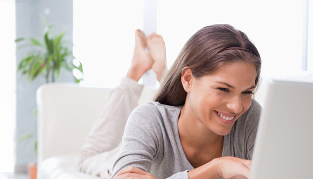Frau auf Couch vor Laptop