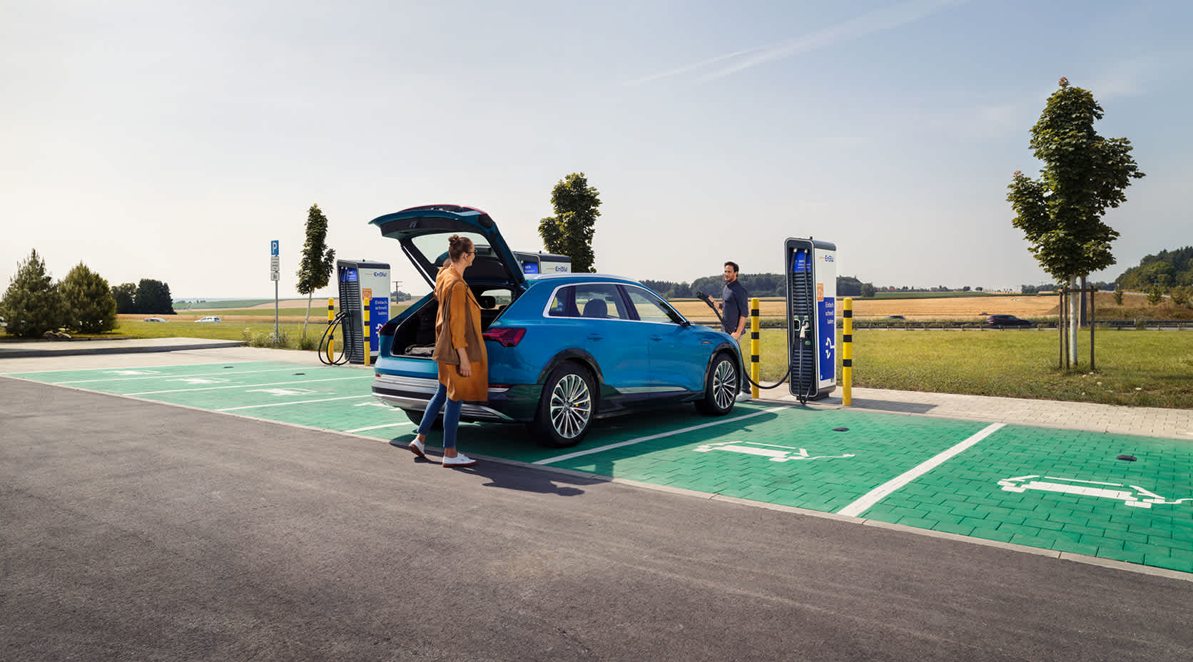 Paerchen mit auto vor einer Ladestationen mit Wilko Ladestecker