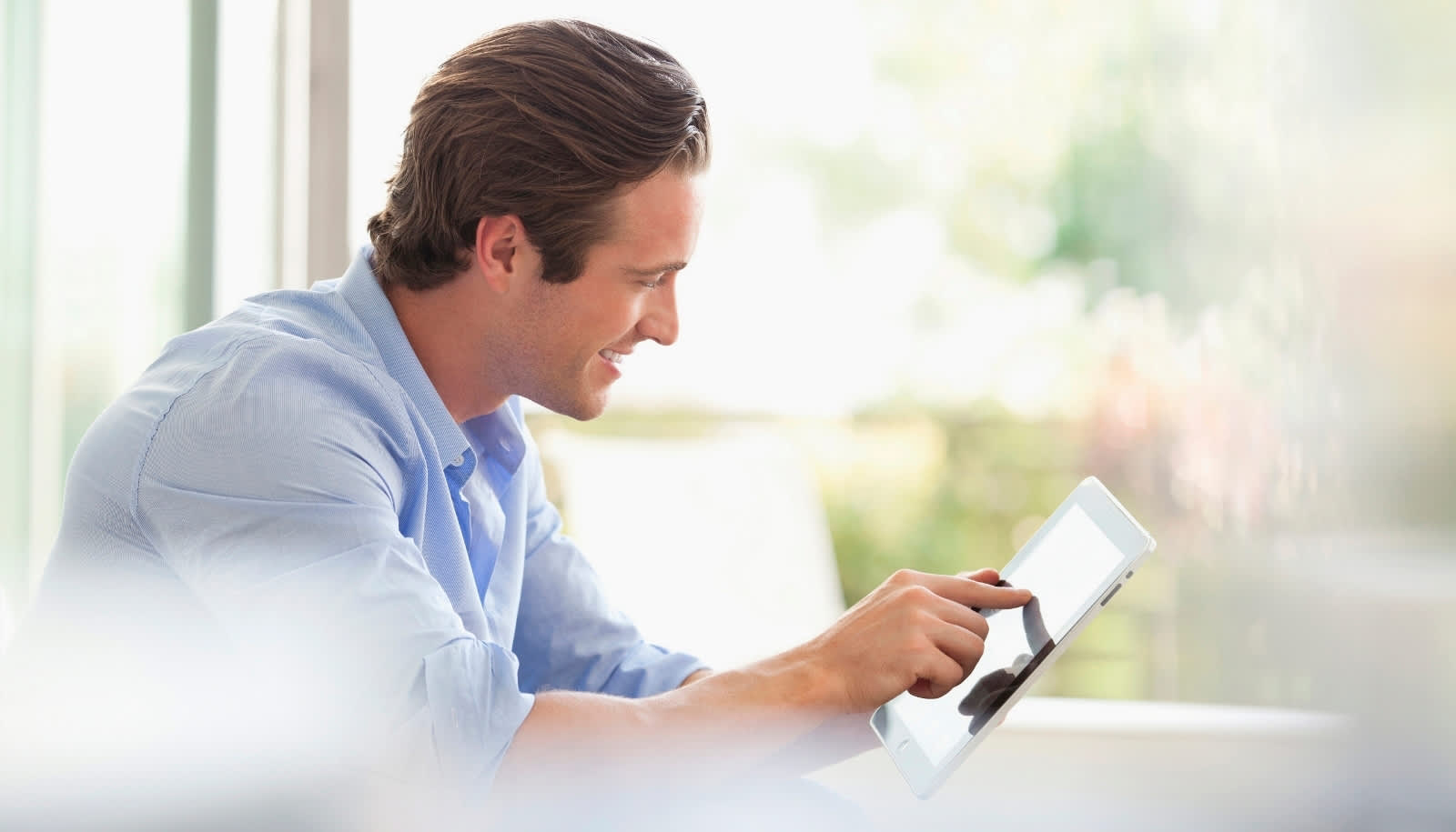 Mann sucht passenden Tarif der EnBW auf Tablet