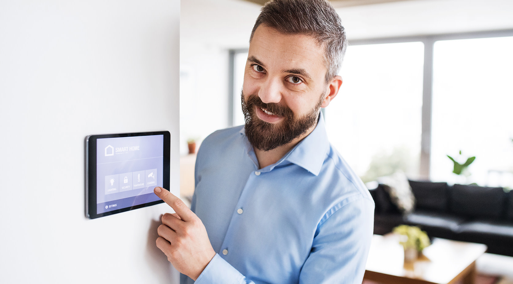 Mann zeigt auf einen Smart Home Bildschirm