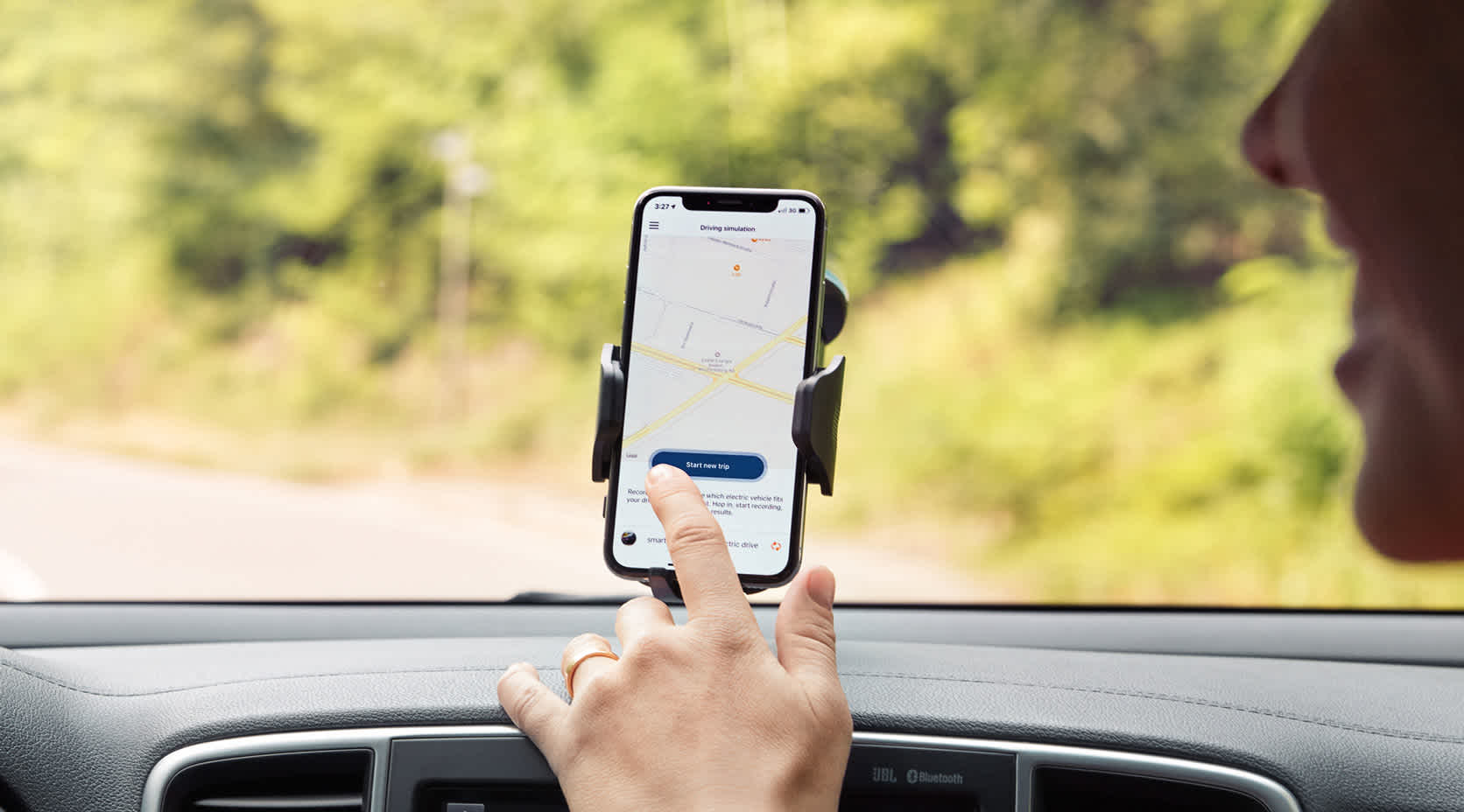Frau zeigt im Elektroauto auf emobility+ App