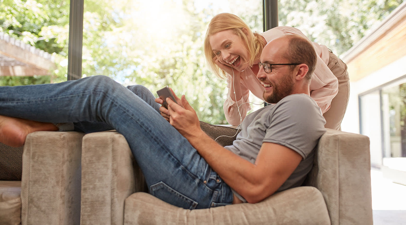 Paar auf Sofa schaut sich die EnBW Stromtarife mit Bundle-Produkten auf Tablet an