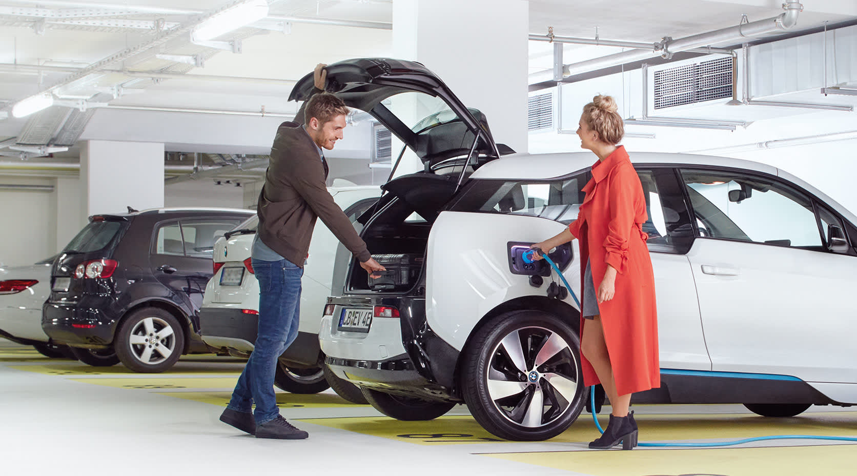 Paar lädt E-Auto im Hotel-Parkhaus