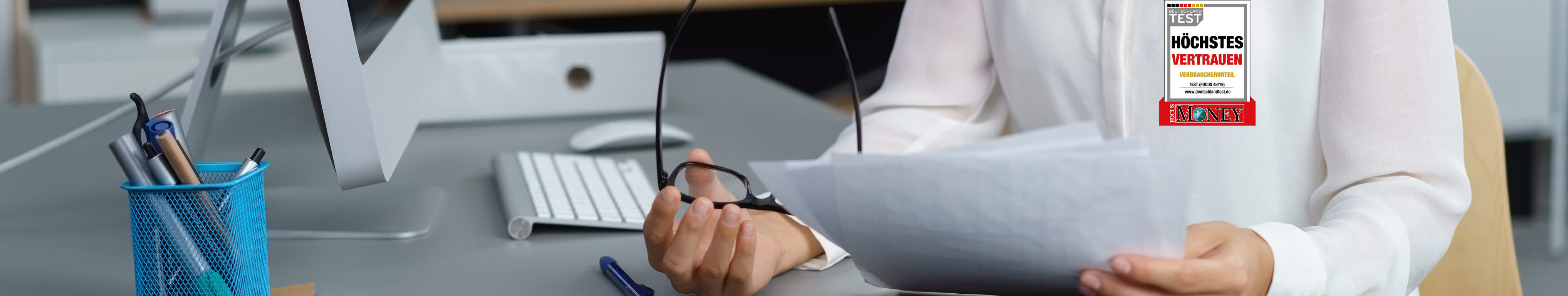 Frau mit Brille schaut auf Rechnung