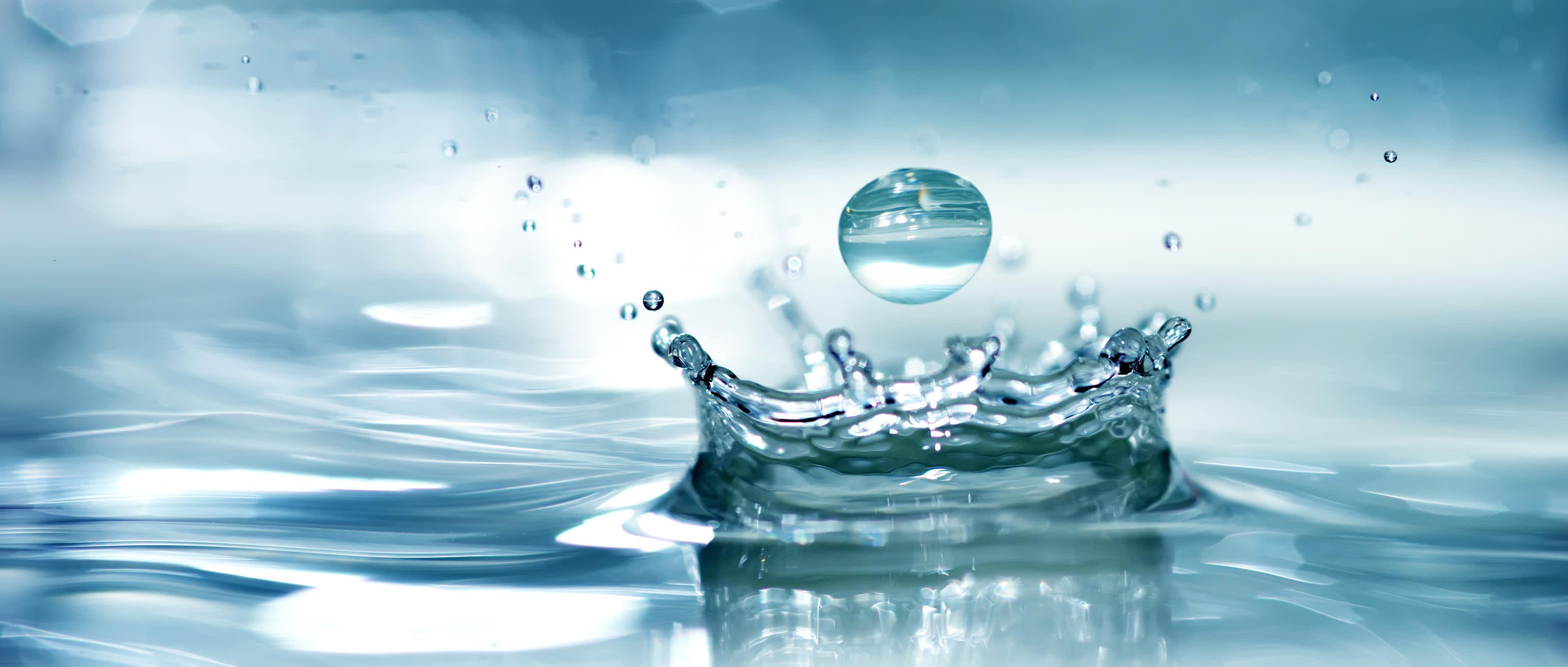 Wassertropfen fällt in frisches Wasser