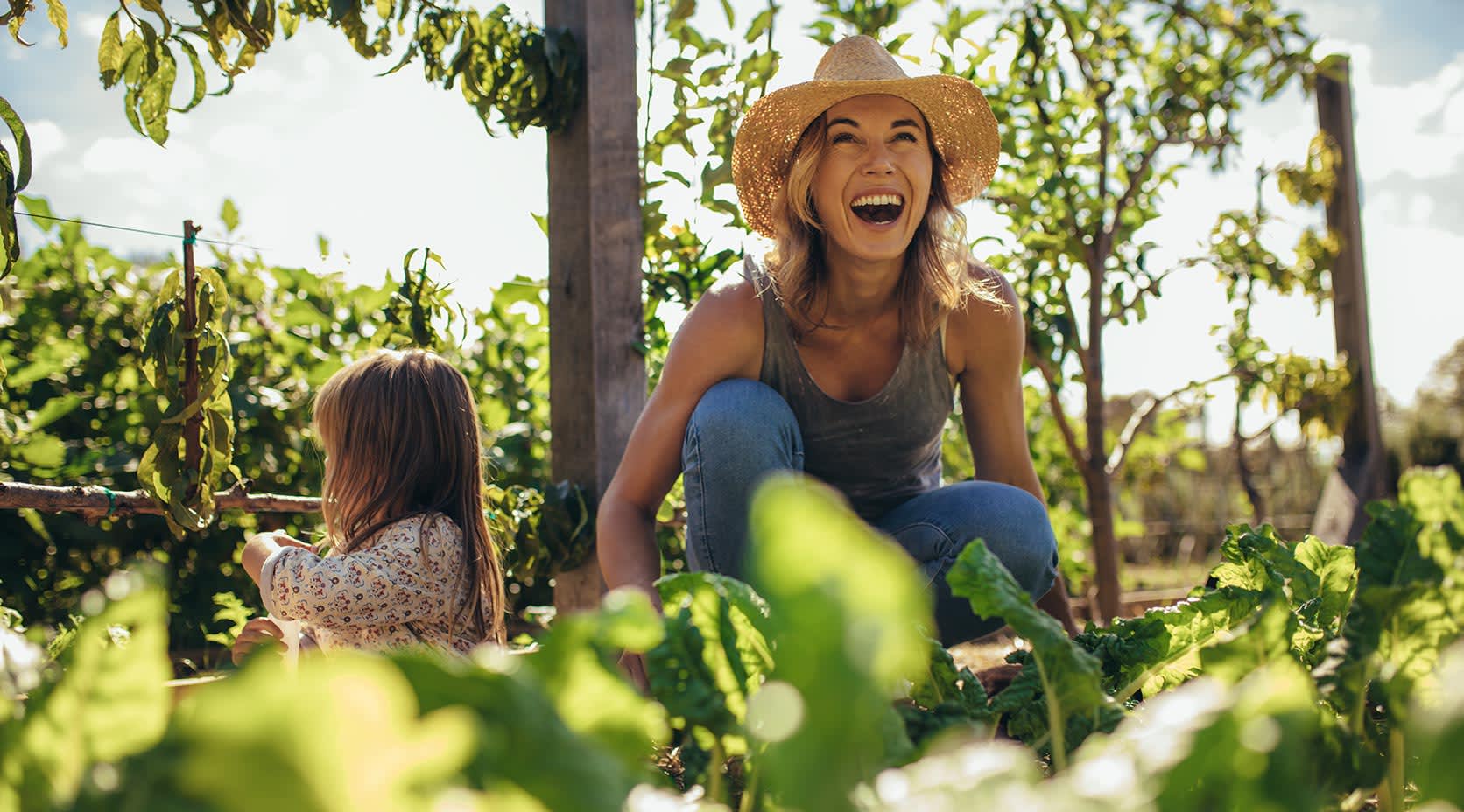 Mutter und Tochter arbeiten gemeinsam im Garten mit Spalierobst