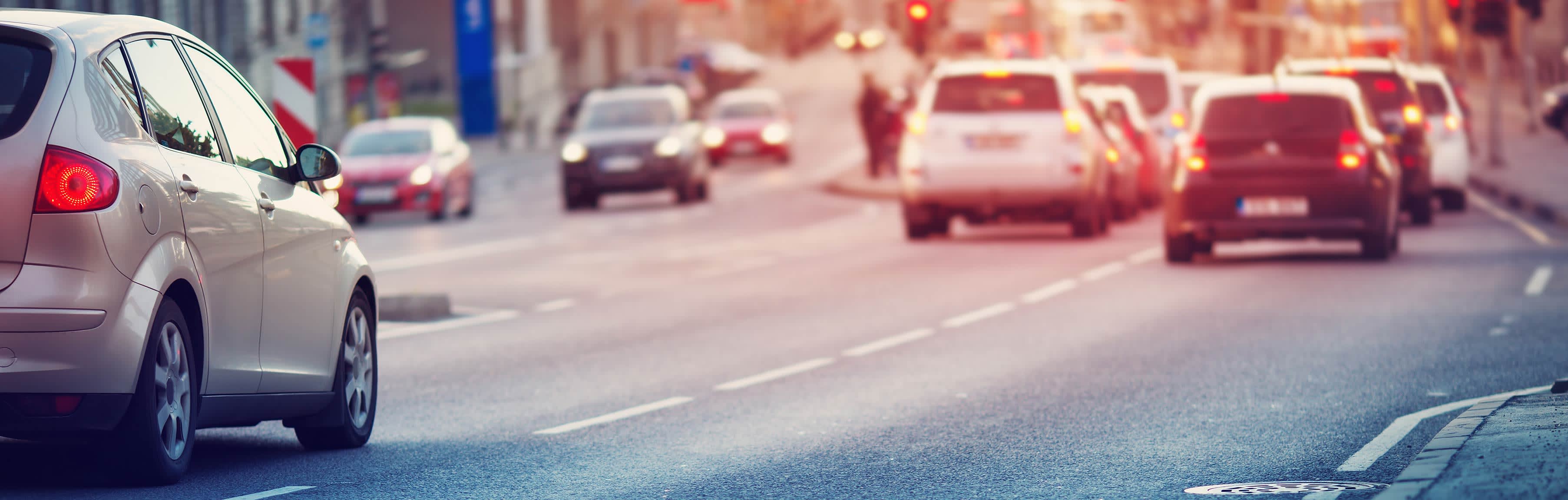 Autos in einer Stadt fahren auf eine Ampel zu.