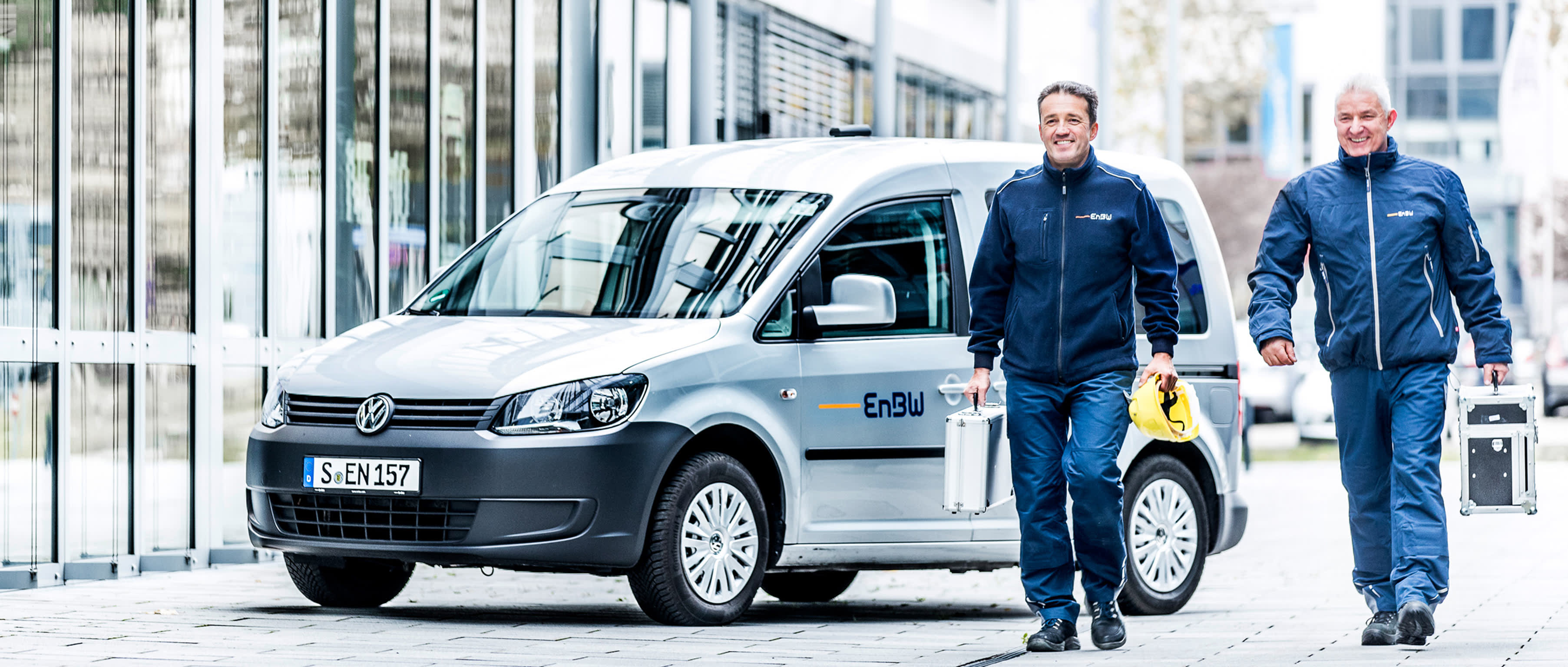 EnBW-Mitarbeiter vor EnBW-Firmenwagen