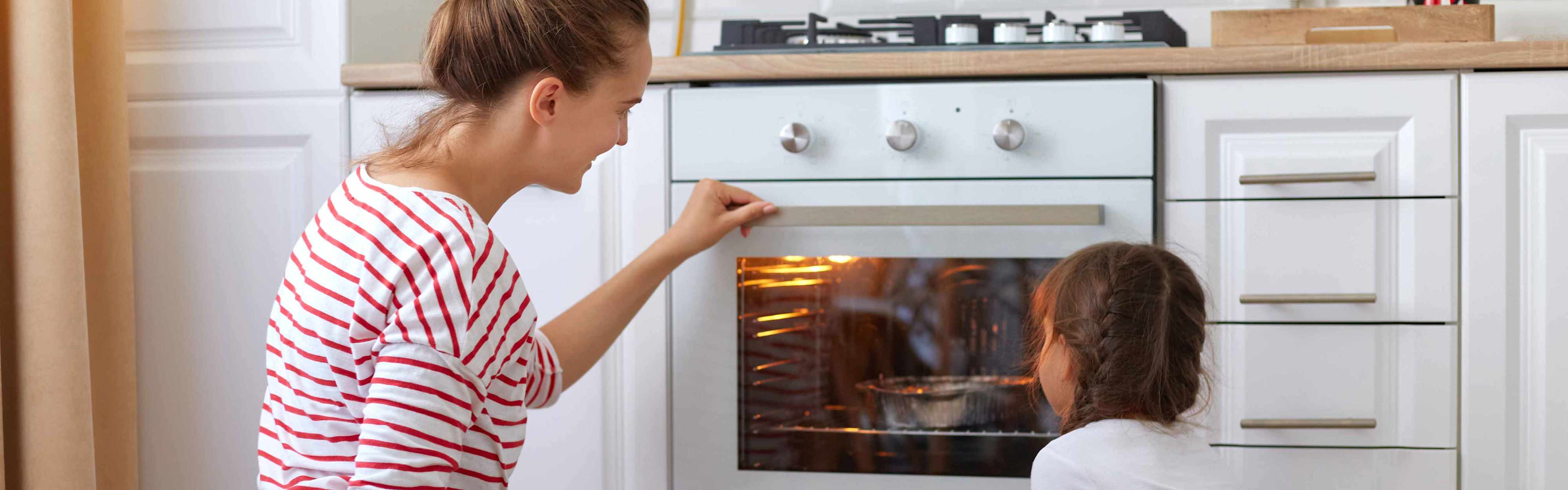Mutter und Tochter vor Backofen
