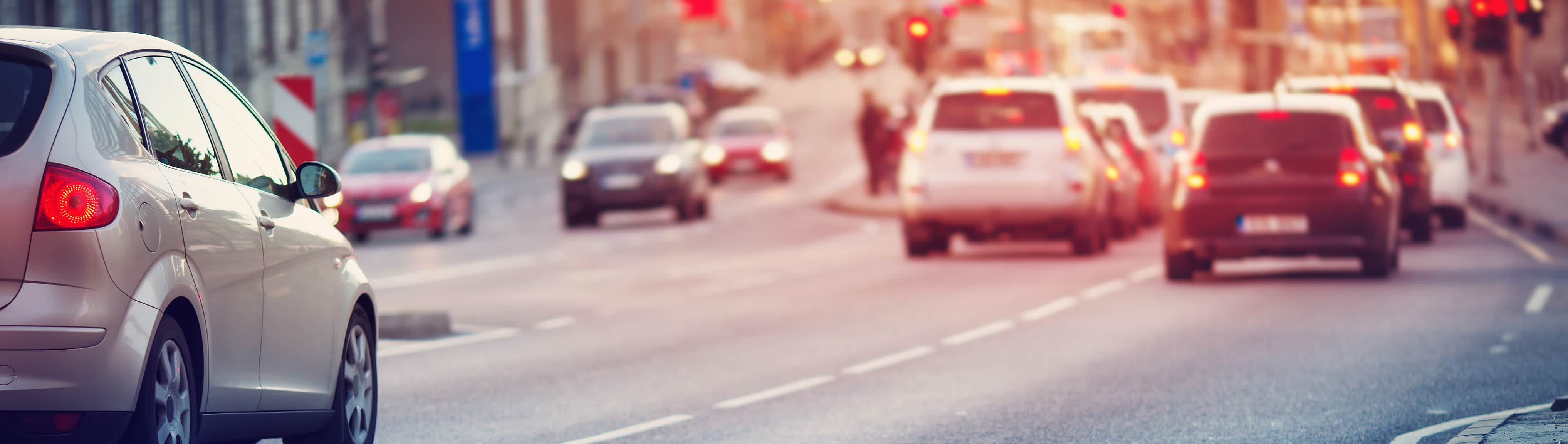 Autos in einer Stadt halten an einer Ampel.