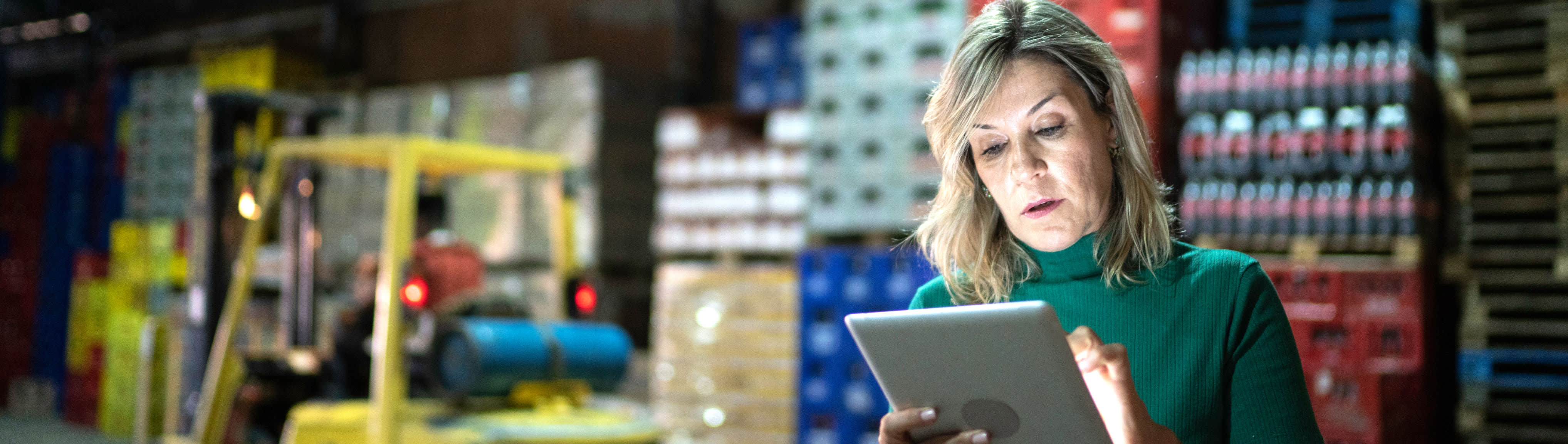 Frau mit Tablet in der Hand in einer Lagerhalle