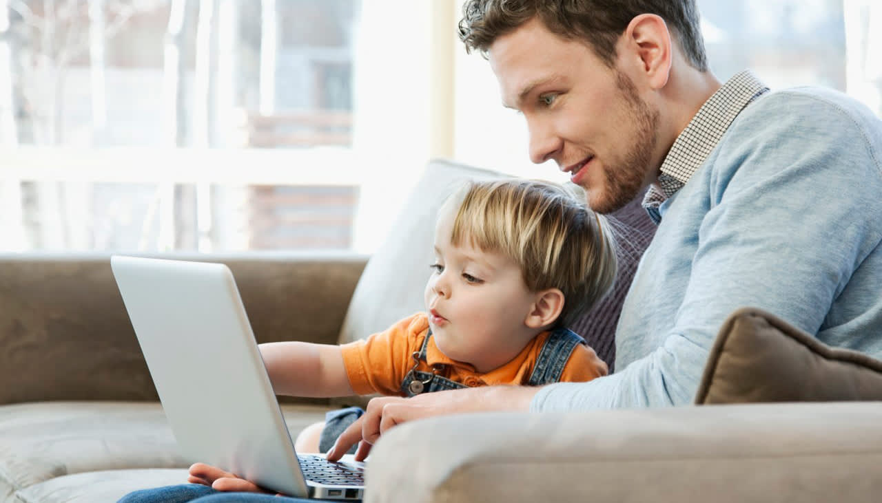 Vater und Kind am Laptop suchen günstigen Stromanbieter