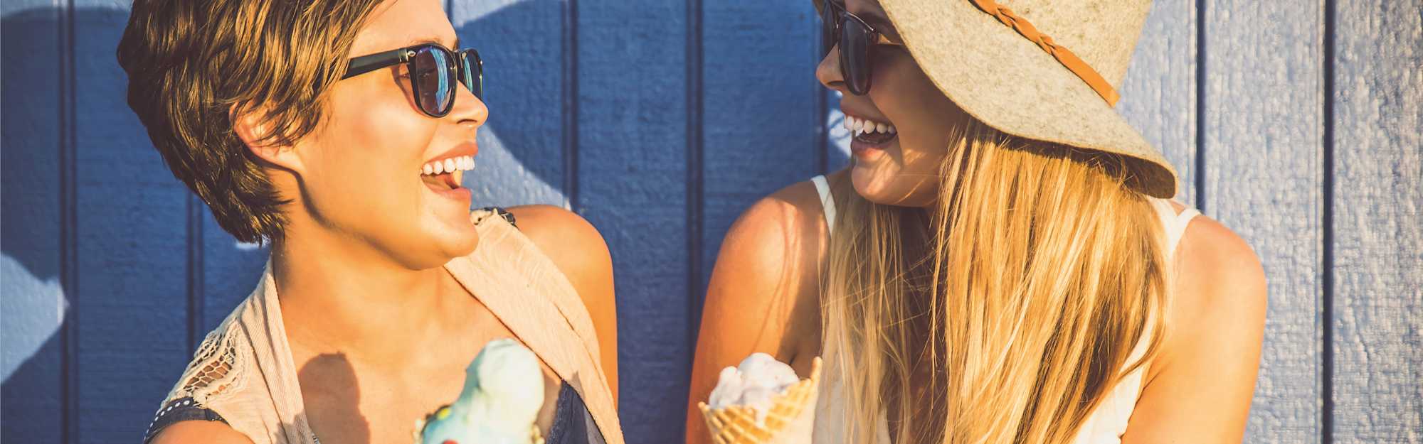 Zwei Frauen mit Eis lachen sich an.