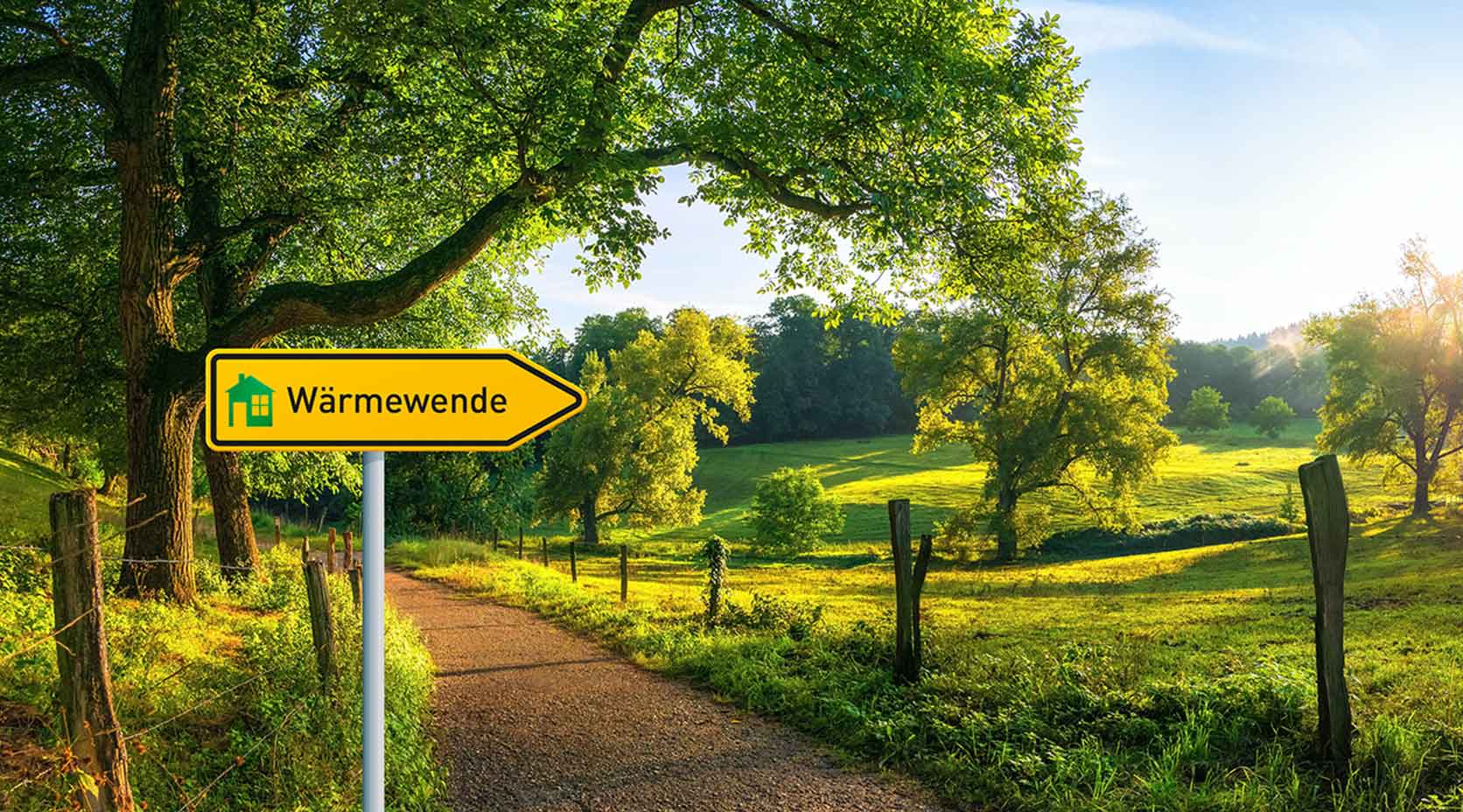 Grüne Landschaft mit einem Straßenschild mit der Aufschrift Wärmewende