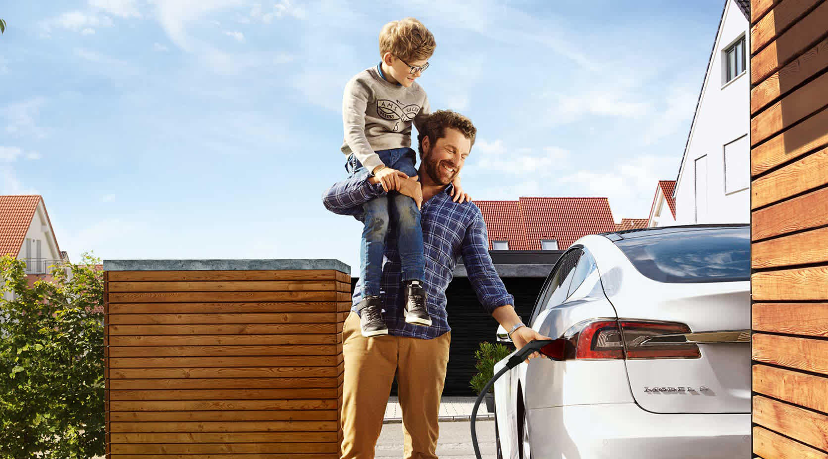 Vater und Sohn laden E-Auto mit EnBW Ladestrom