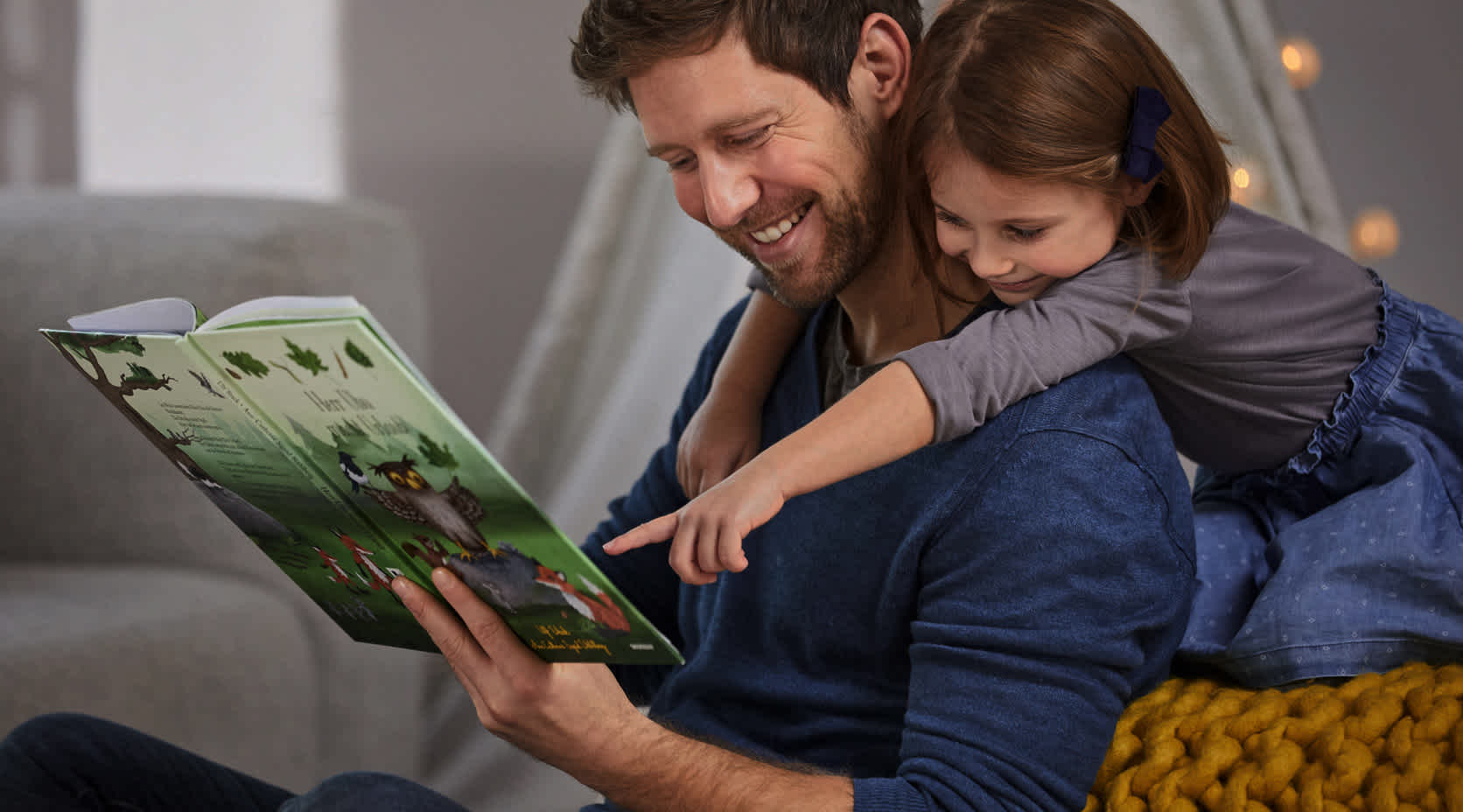 Vater liest Tochter aus einem Buch vor