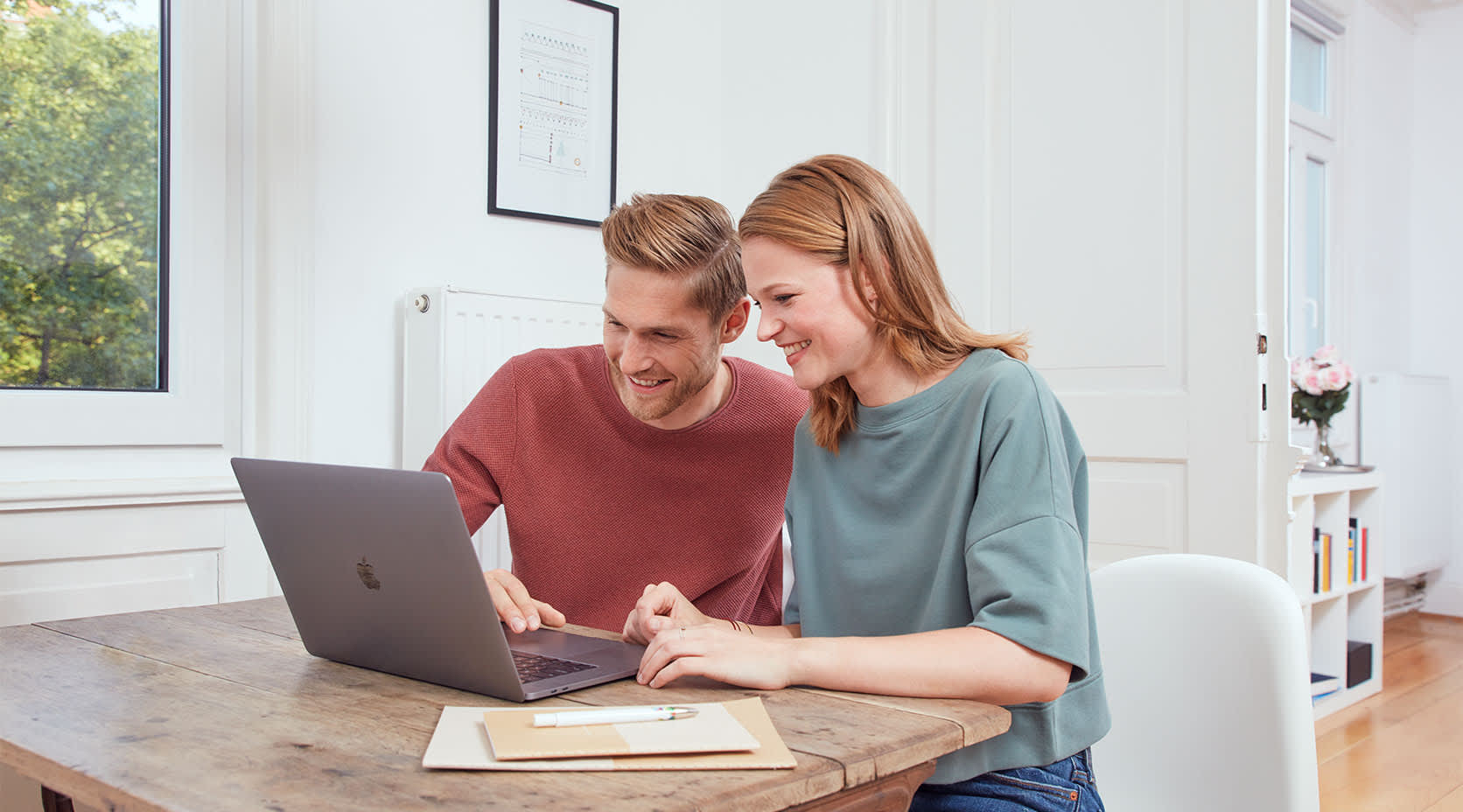 Frau mit Mann sitzen am Laptop