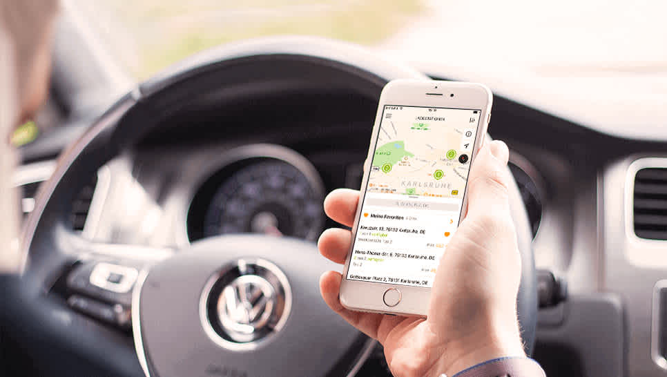 Autofahrer hält Smartphone mit der EnBW mobility+ App in der Hand