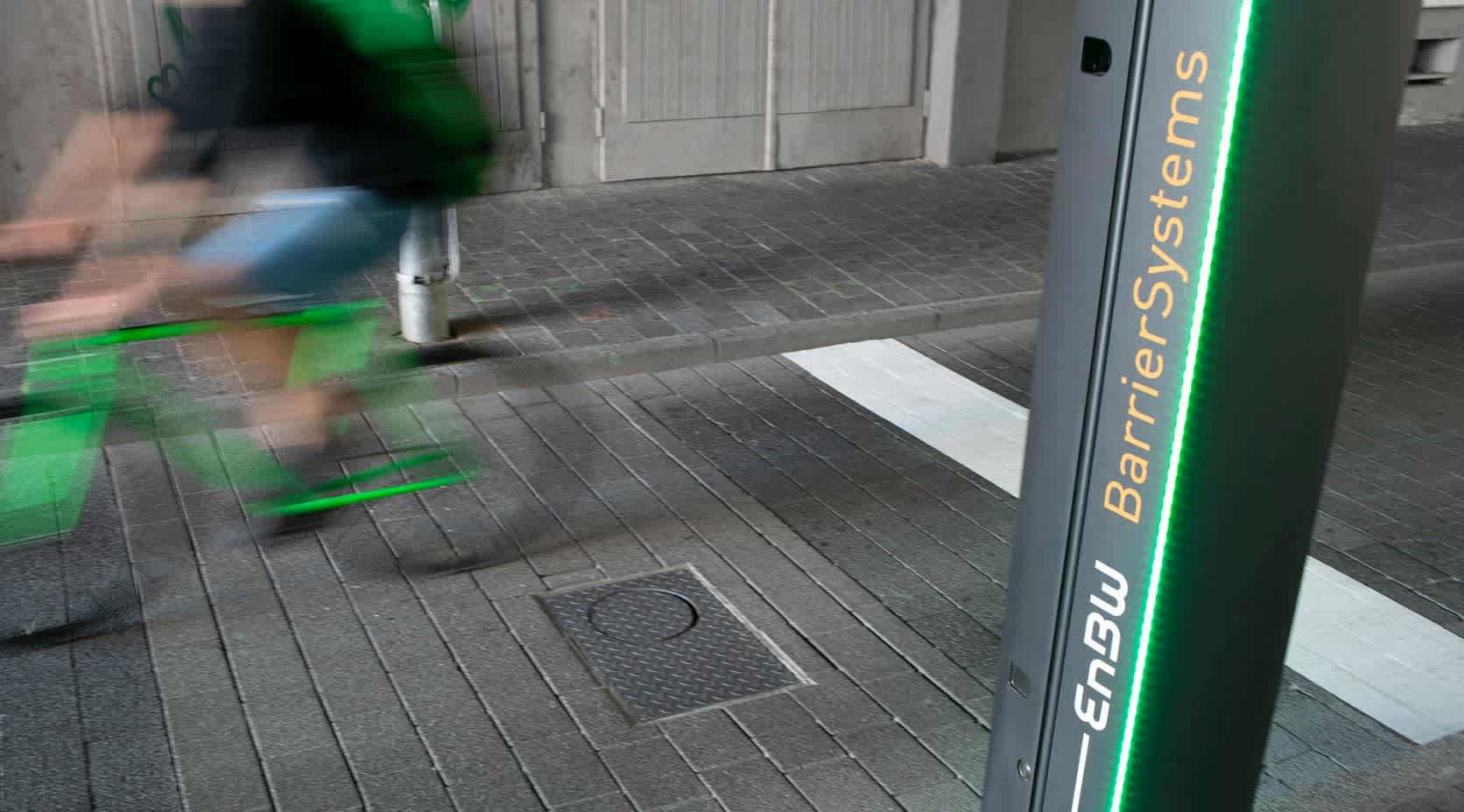 Ein Radfahrer fährt an einer Stele der EnBW BarrierSystems vorbei.