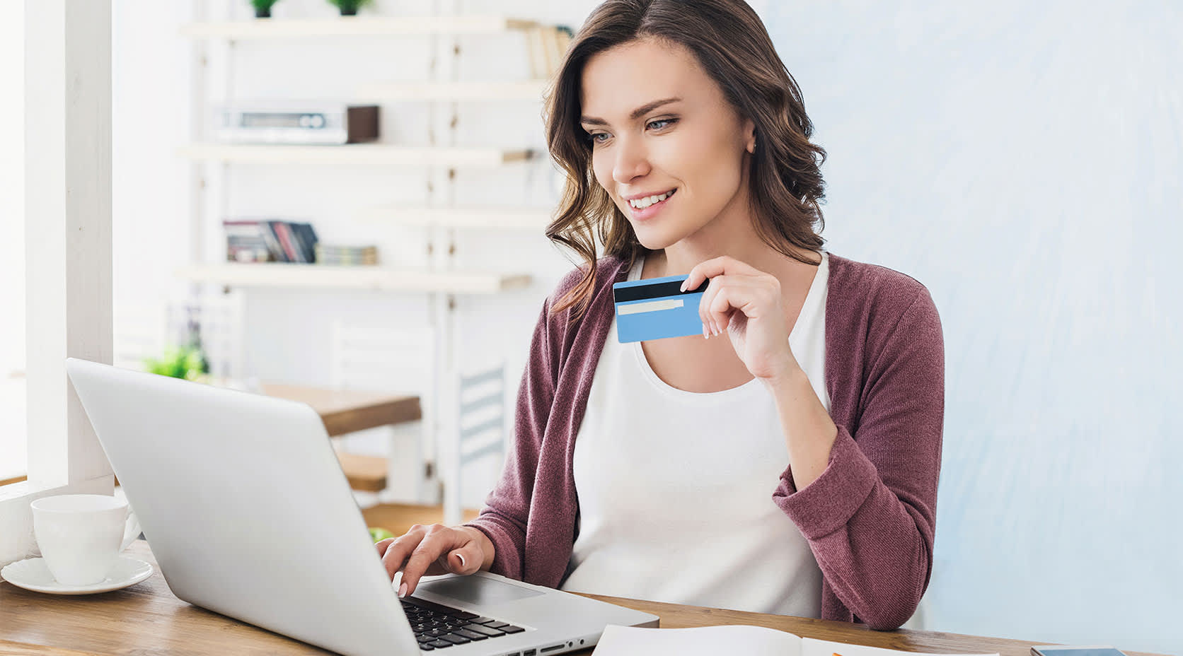 Frau mit Bankkarte am Laptop