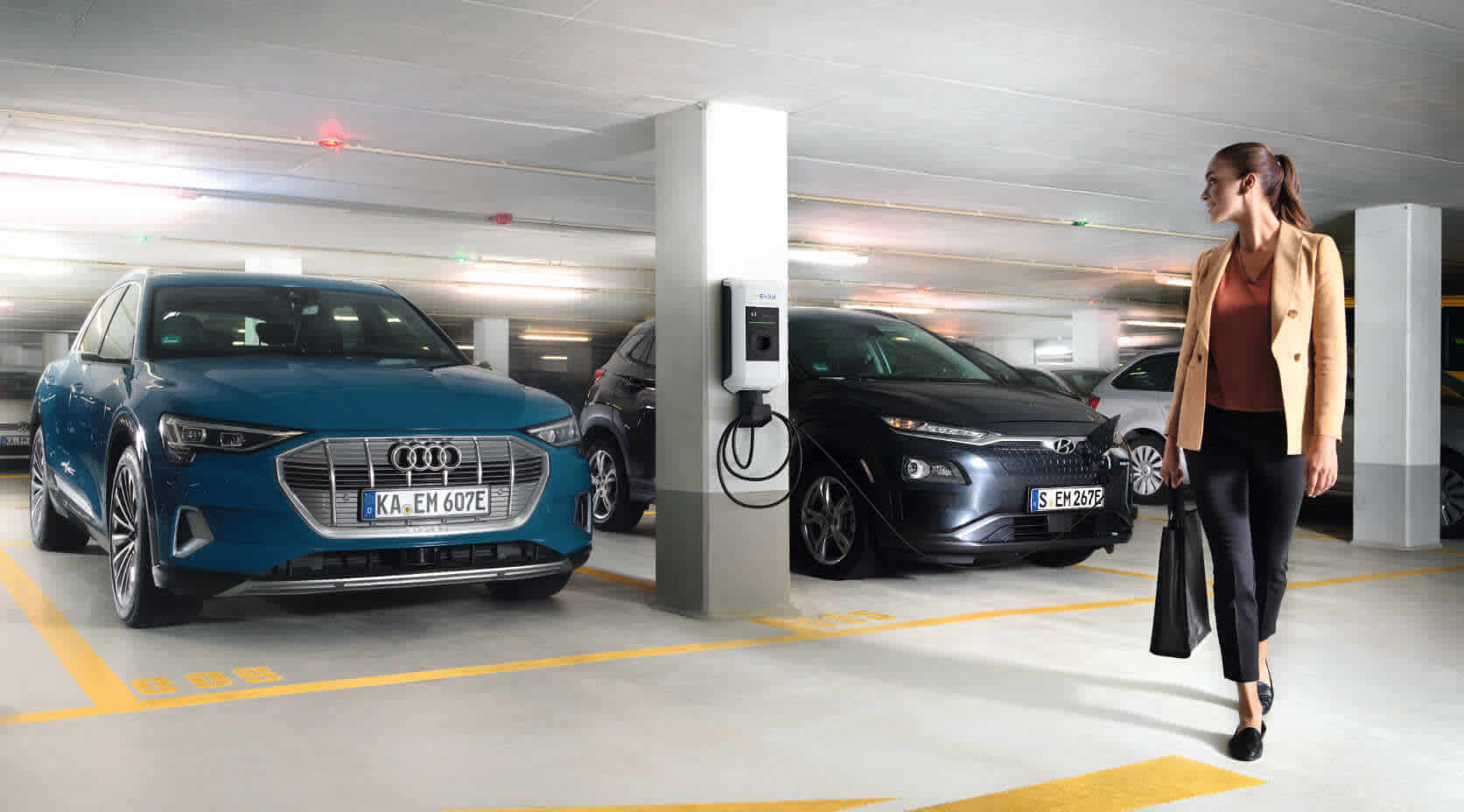 Frau lädt E-Auto in Firmen-Tiefgarage auf