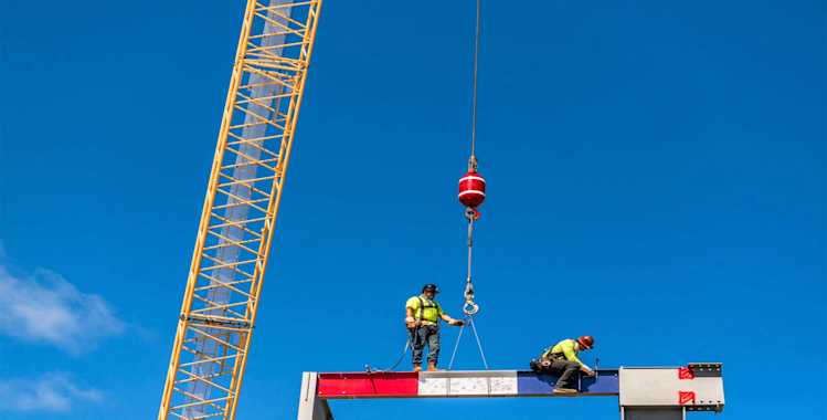 Construction workers place final beam atop of the Mountain View High School structure in Vancouver, Washington.