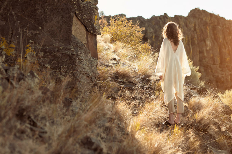 Woman in white poncho in desert