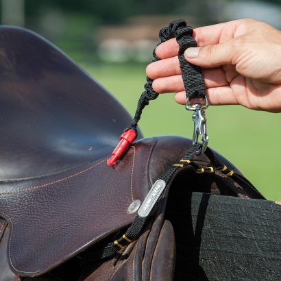 Safety air vest lanyard attached to a saddle stirrup bar. 