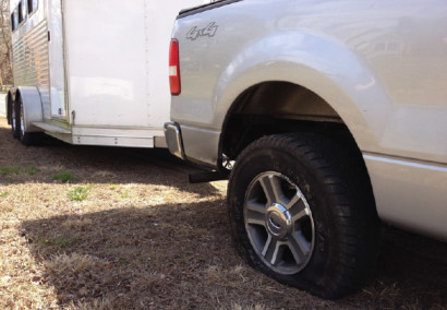 A flat tire on a truck and trailer.