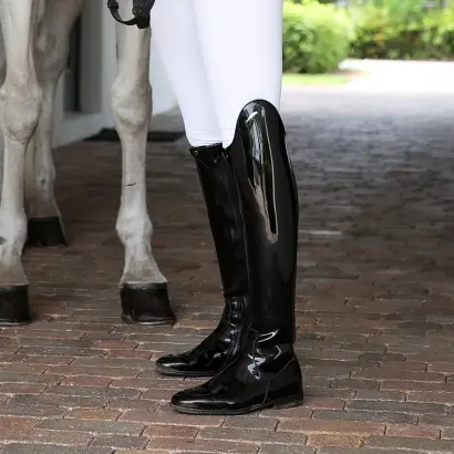 A rider wearing patent leather dressage boots.