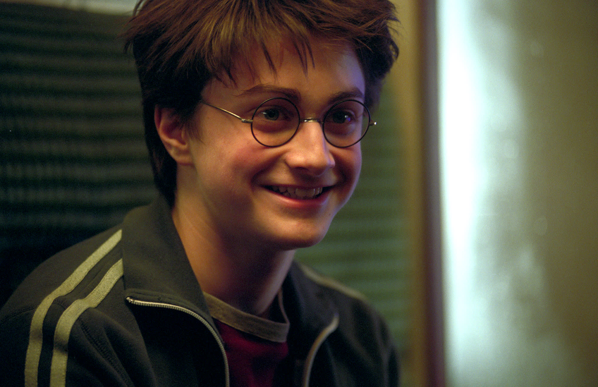 Harry smiling while sat in a compartment on the Hogwarts Express