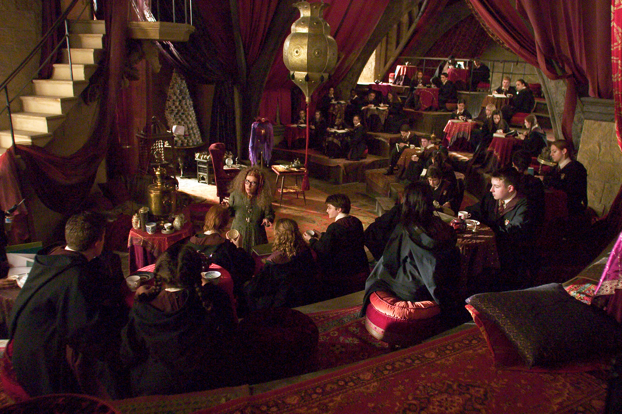 The Divination classroom. Students sit at round tables in staggered rows with Trelawney teaching at the front of the class.