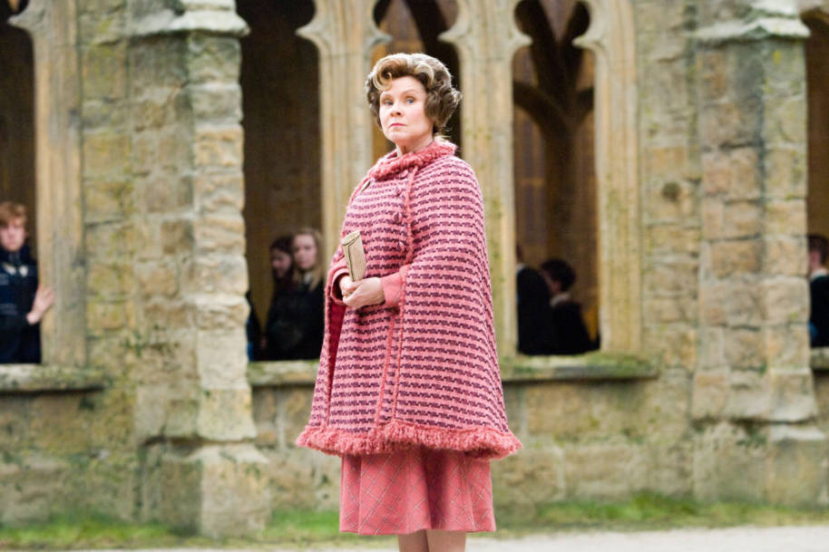 Umbridge sneers at Professor Trelawney in the Hogwarts courtyard.