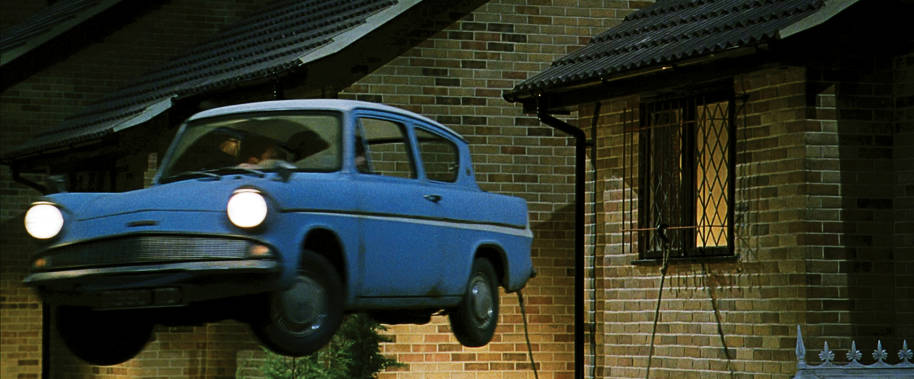 The Weasley's blue flying car in the air, with a rope tied to the bars on Harry's window at Privet Drive.