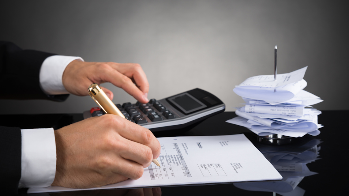 iStock 518433706 => Taschenrechner, Rechnung, Quittungen, Belege, Schreibtisch, Stift, arbeitende Hände
