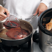 Deglaze the sauté pan with red wine, scraping up any browned bits left on the bottom. 